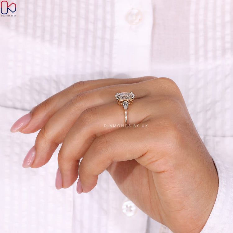 4 prong claw setting with an oval diamond ring and marquise side stones for added elegance.
