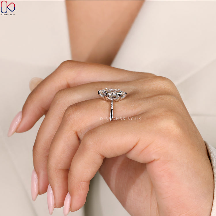 4 Prong Claw Setting Marquise Diamond Ring with round side diamonds and a tapered shank band for a timeless look.
