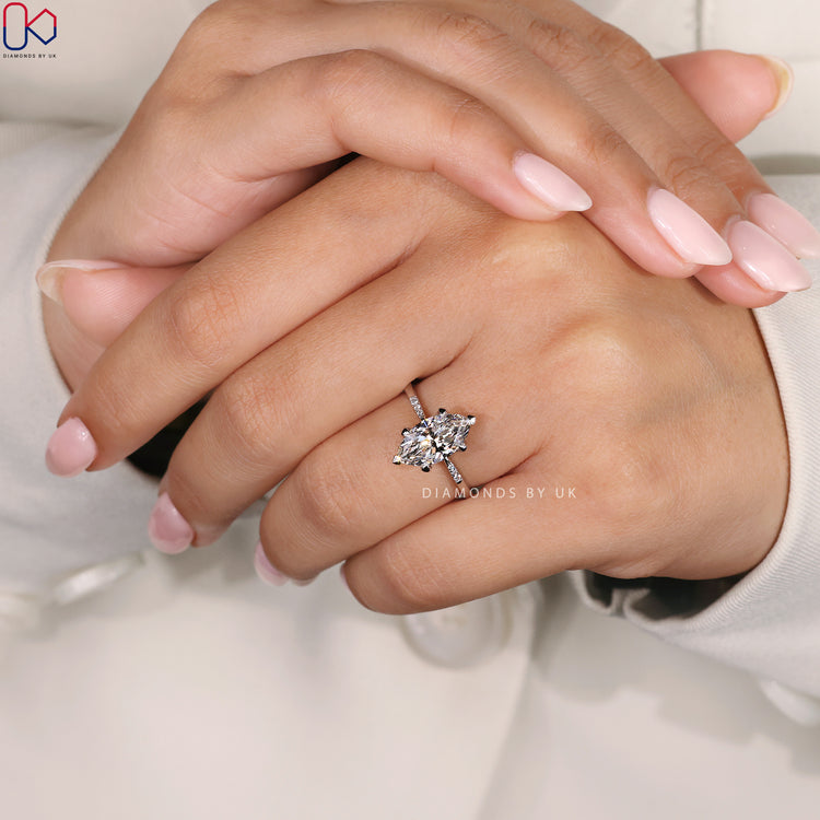 Proposal Ring for Her, featuring a stunning Marquise Diamond with round side diamonds and a tapered shank band.
