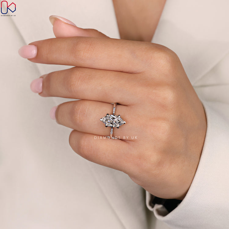 Round Side Diamond Ring with Marquise Center Diamond, set in a 4 prong claw setting on a tapered shank band.
