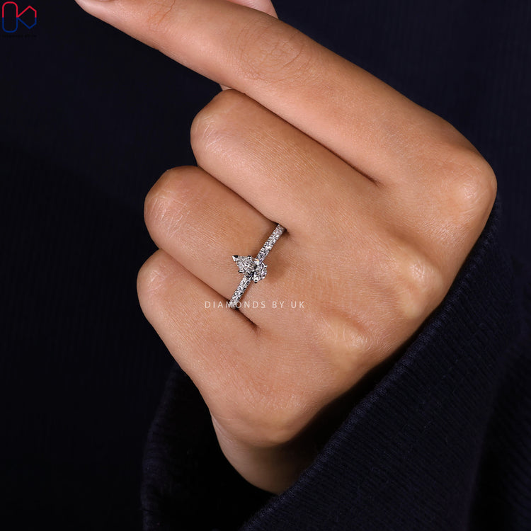 Lab grown diamond ring with pear cut and round accents.
