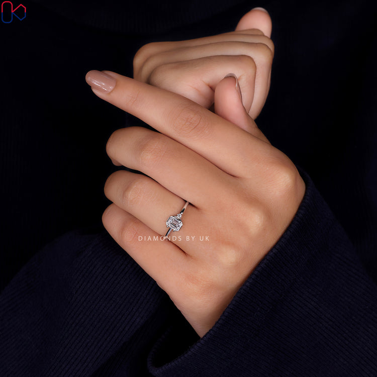 Prong setting ring featuring round and emerald cut diamonds.