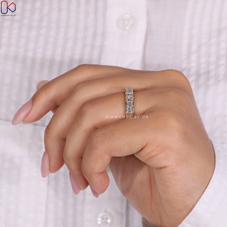 Channel set eternity band featuring princess cut diamonds for a seamless look.

