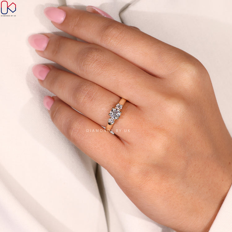 Diamondsbyuk Ring showcasing three round diamonds in a prong setting for engagement.
