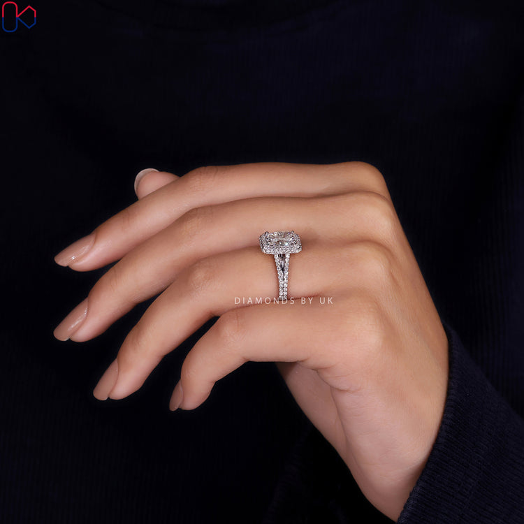 White gold engagement ring with a radiant cut diamond in a pave setting.