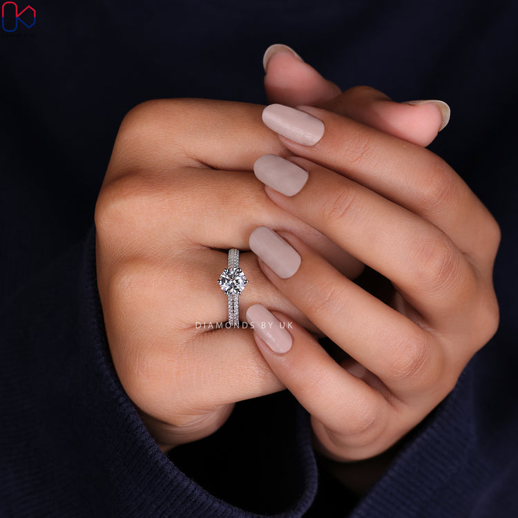 Handmade ring featuring a radiant round cut diamond ring with pave accents.