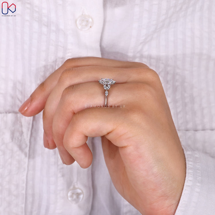 Lab grown marquise cut side stone engagement ring.
