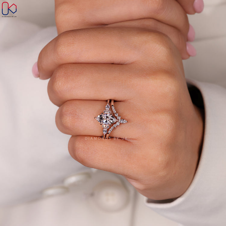 Side stone ring featuring round and marquise cut diamonds.
