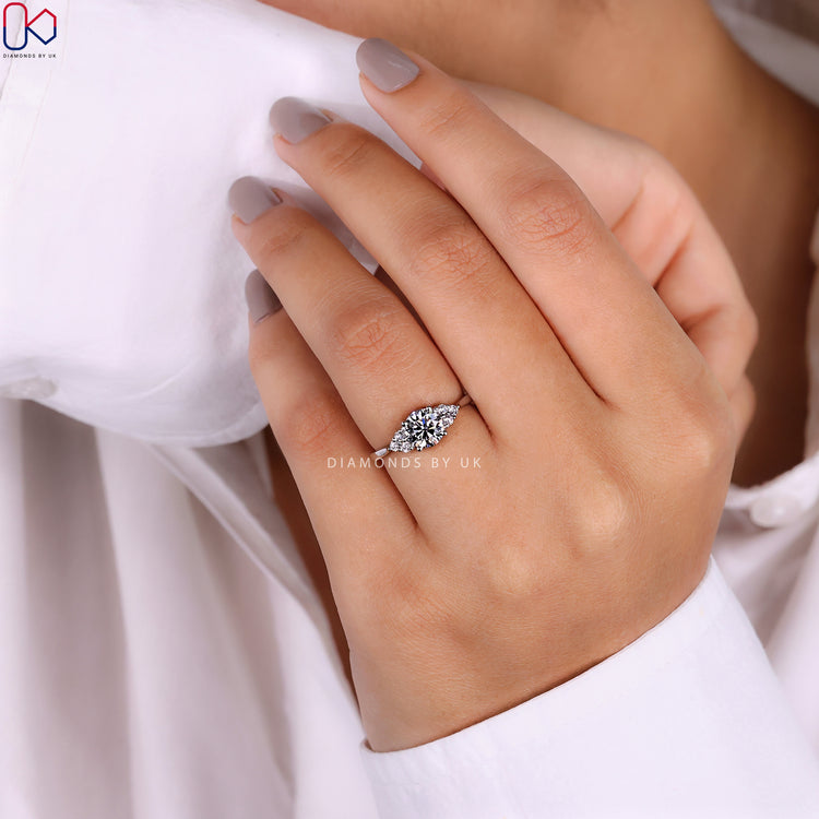 Round cut side stone with white gold engagement ring.
