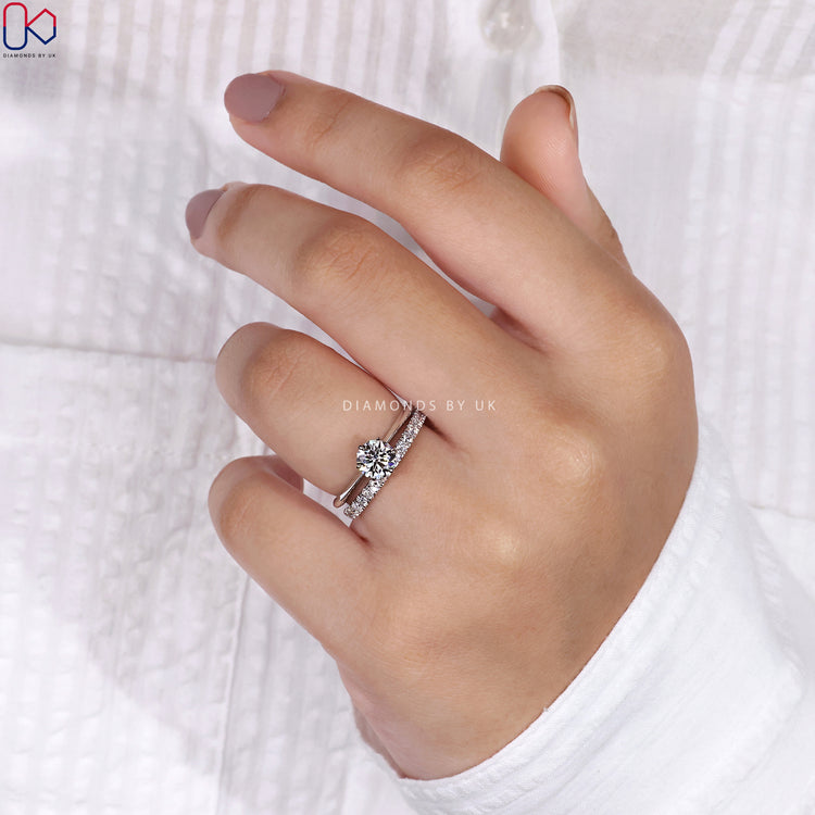 Round cut wedding band paired with a dazzling engagement ring.

