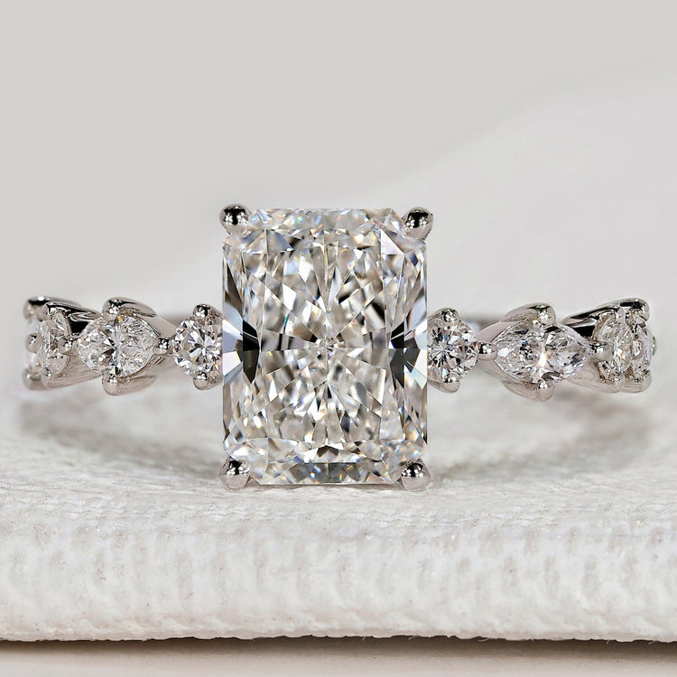 Radiant cut ring with marquise and round pavé diamonds.
