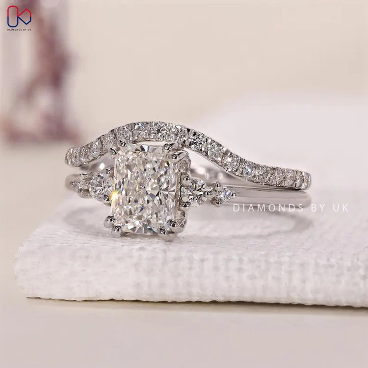 Radiant diamond ring with double prong setting and curved band.