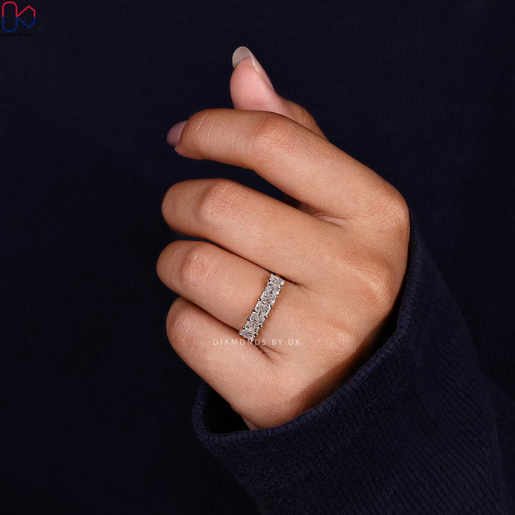 Simple wedding band with radiant cut diamonds in a smooth yellow gold band.
