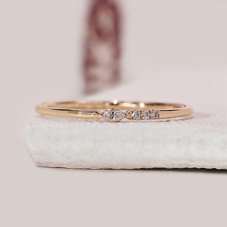 Four diamond wedding band crafted with marquise and round cuts in a prong setting.
