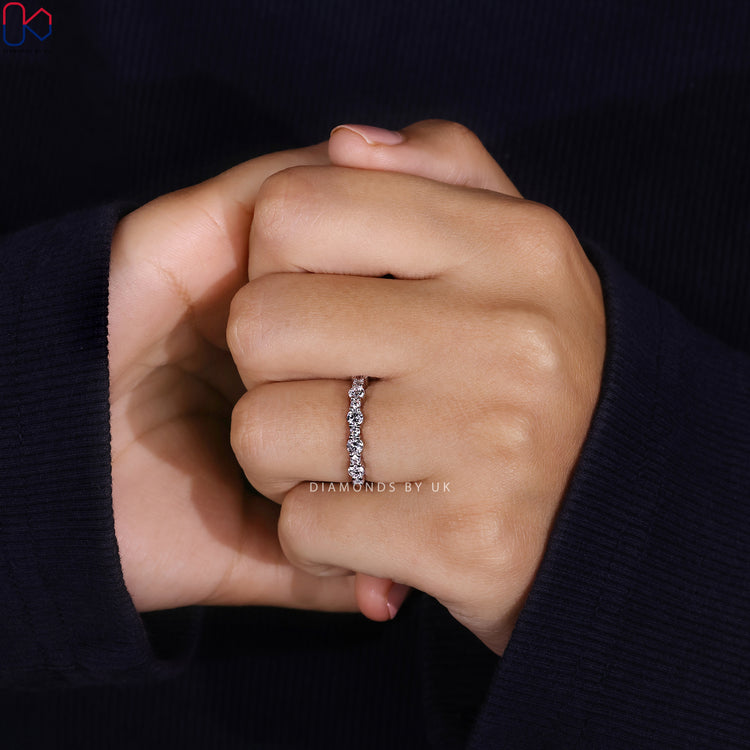 Round cut diamond band with prong set half eternity style.