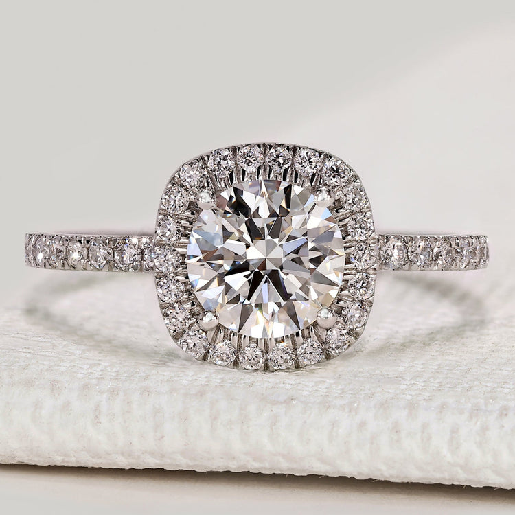 Round cut engagement ring with halo and pavé style.
