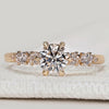 Round cut diamond ring with side stone design.