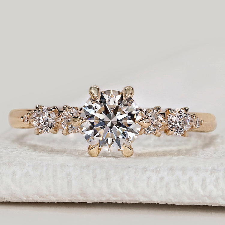 Round cut diamond ring with side stone design.