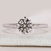 Round cut solitaire ring with four claw compass prongs.
