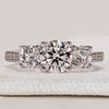 Round cut three stone ring with pavé tapered shank.
