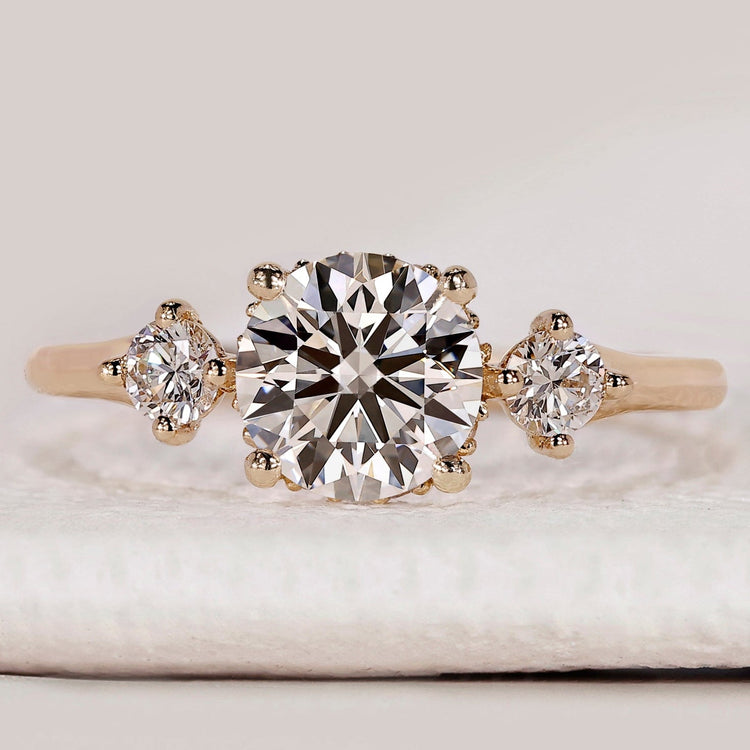 Round cut three stone ring with hidden halo design.
