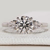 Round cut ring with pear side stones and cathedral setting.
