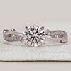 Round cut ring with twisted pavé and hidden halo.
