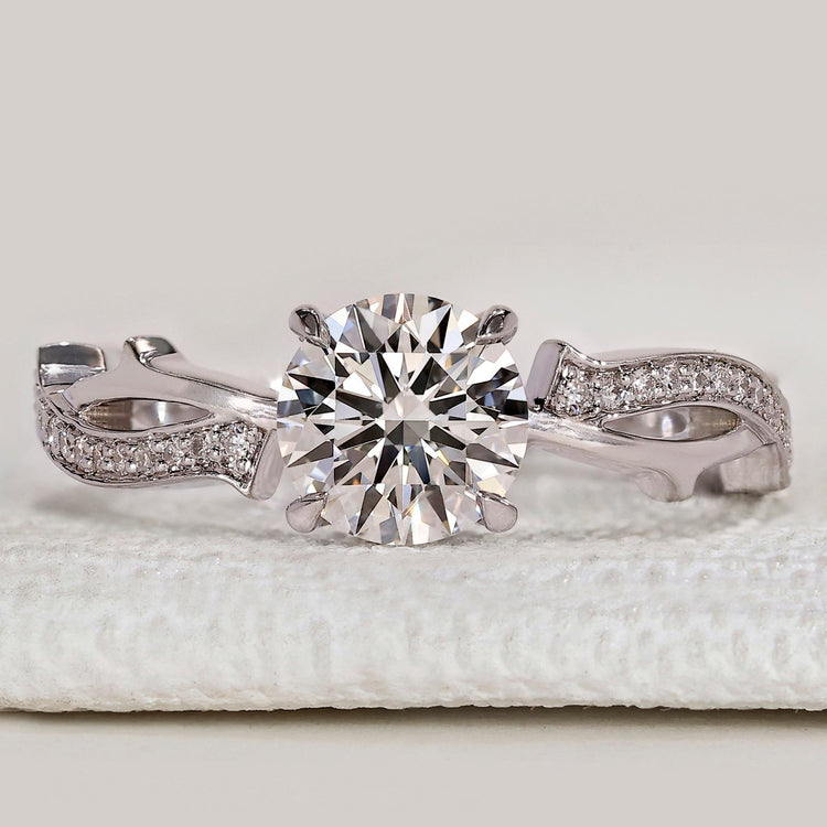 Round cut ring with twisted pavé and hidden halo.
