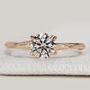 Round cut solitaire ring with hidden stones setting
