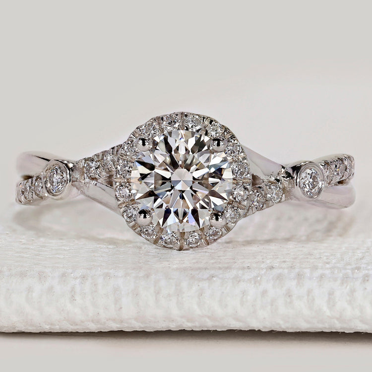 Round cut engagement ring with halo and twisted pavé.