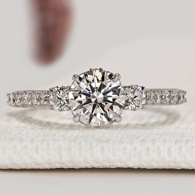 Round diamond three stone ring with pavé style.
