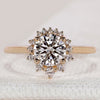 Round diamond ring with cluster halo and four prongs.
