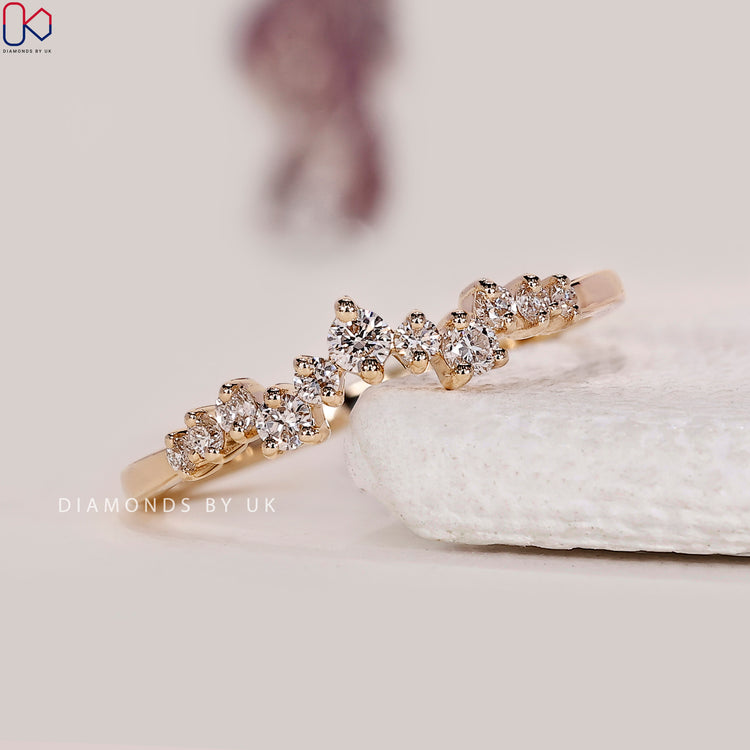 Curvy wedding band featuring lab grown round diamonds in a prong setting.
