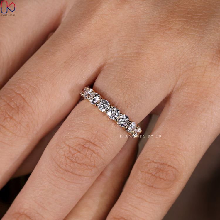 Elegant prong set diamond band available in yellow gold.

