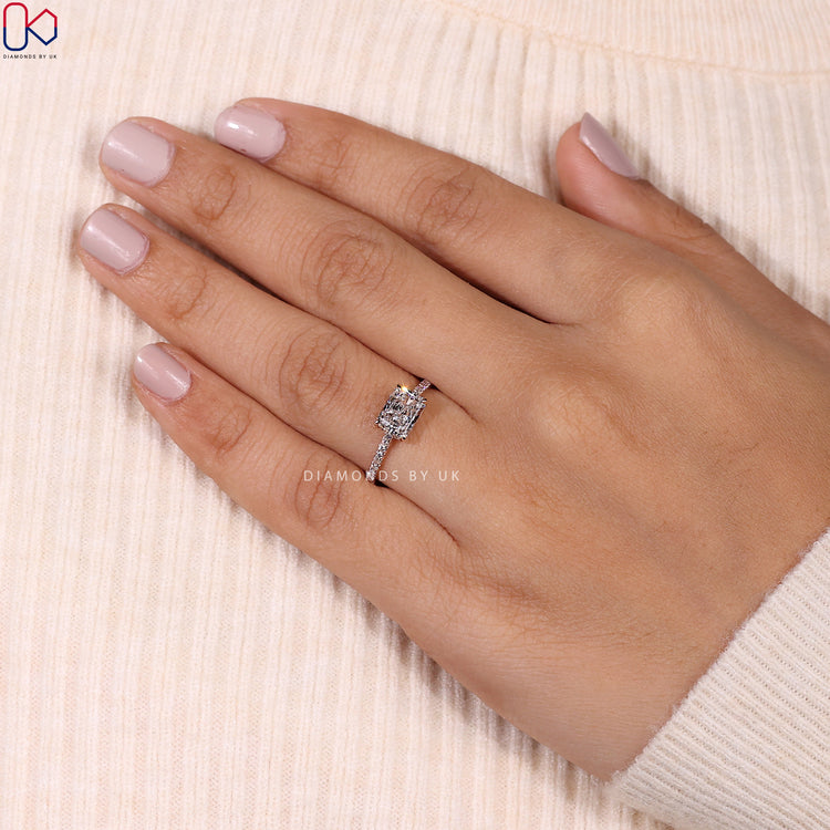 Radiant cut diamond ring with sleek pave set detailing.
