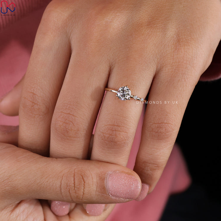 Yellow gold ring with three prong setting and round side stone engagement ring.
