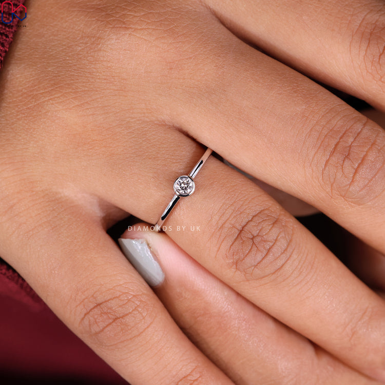Minimalist engagement ring with a round cut diamond.

