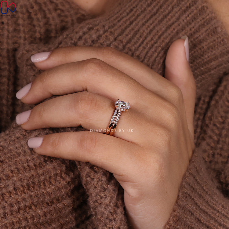 Hidden halo ring with oval engagement stone and round diamond band.
