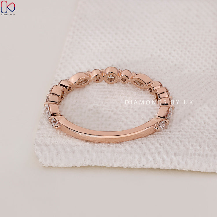 Yellow gold wedding band featuring round and marquise diamond accents.

