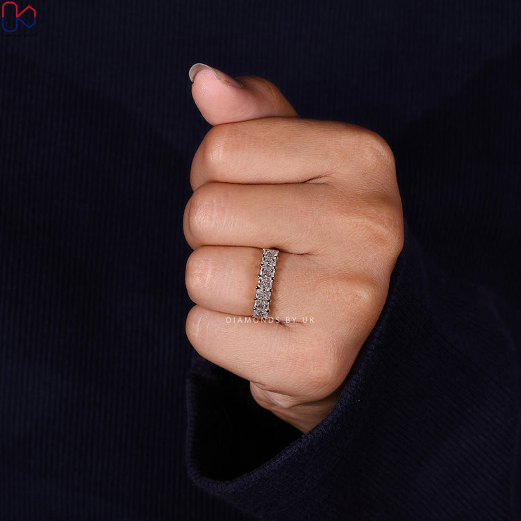 Prong set wedding band with radiant lab grown diamonds arranged in a half eternity line.
