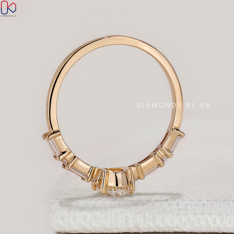 Oval ring with four prong and pavé diamond band.
