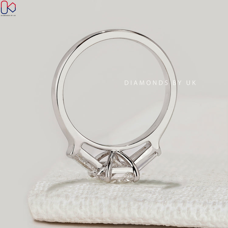 Pear diamond ring with round cut side diamonds.
