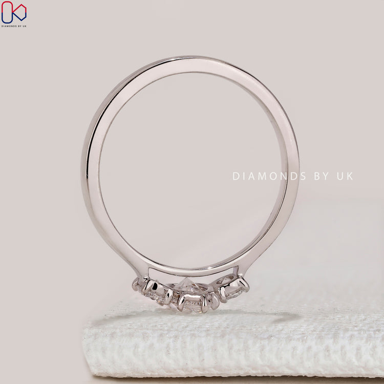 Pear diamond ring with round cut side diamonds.