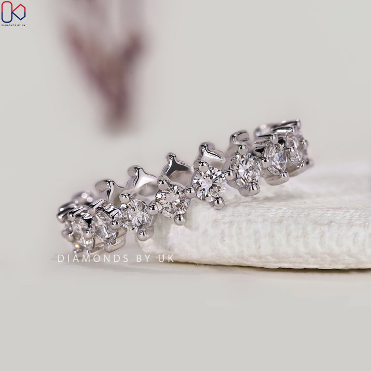 Round diamond eternity band with compass prong setting.