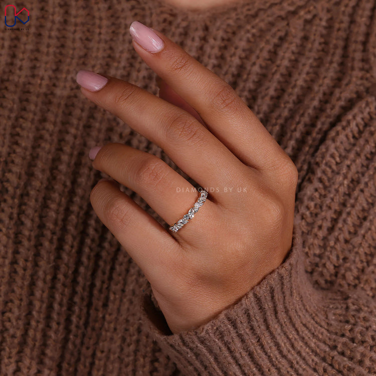 Half eternity wedding band with marquise and round stones in a balanced pattern.
