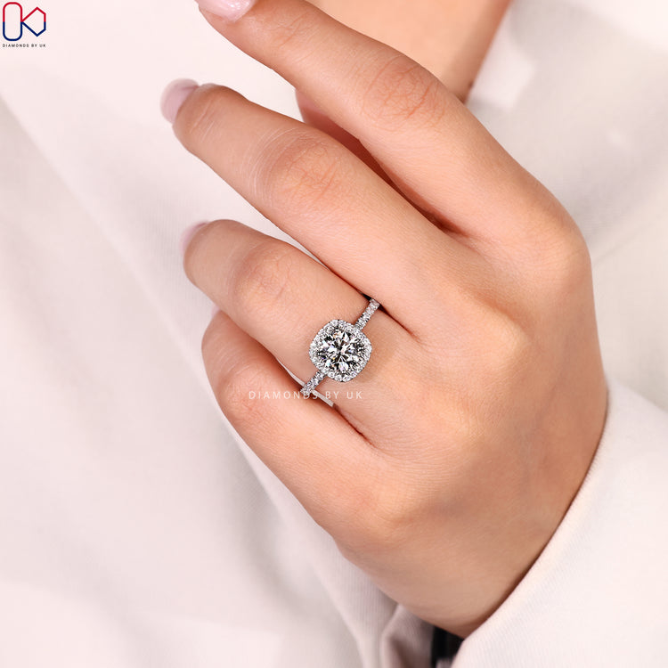 Round cut diamond ring with halo pavé design.