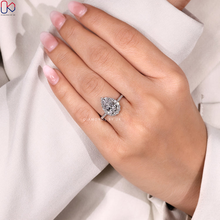 Pear cut diamond ring with halo pavé design.