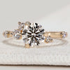 Round cut engagement ring with cluster round diamonds.