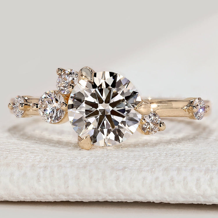 Round cut engagement ring with cluster round diamonds.