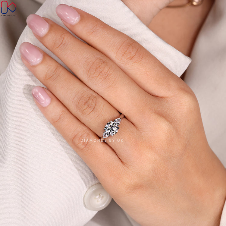 Round cut ring with three stone cathedral style.